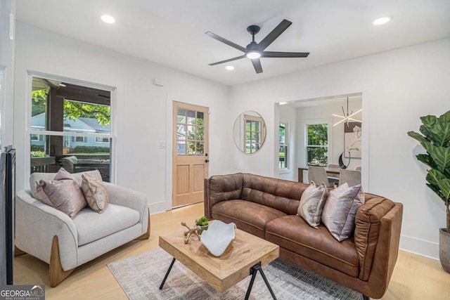 living area with light wood-type flooring, recessed lighting, a ceiling fan, and baseboards
