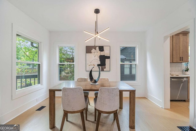 dining area featuring light wood finished floors and baseboards