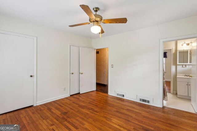 88 Karland Dr NW, Atlanta, GA 30305 - unfurnished bedroom with wood finished floors, multiple closets, connected bathroom, baseboards, and a ceiling fan