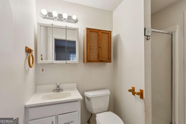 bathroom with a stall shower, vanity, and toilet