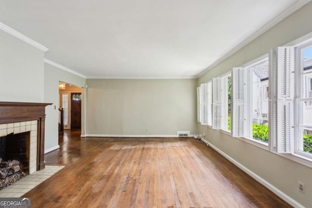 unfurnished living room featuring hardwood / wood-style flooring, a fireplace, baseboards, ornamental molding, and a chandelier