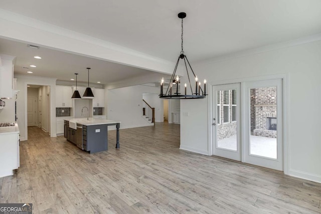 1241 Riverhill Dr, Bishop, GA 30621 - kitchen featuring a chandelier, light countertops, a sink, light wood-style floors, and white cabinets