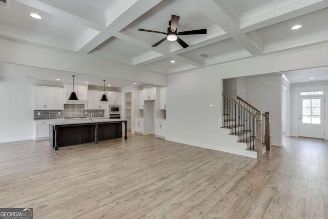 1241 Riverhill Dr, Bishop, GA 30621 - unfurnished living room with light wood finished floors, stairway, beam ceiling, coffered ceiling, and ceiling fan