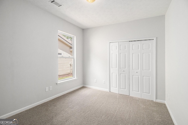 712 Brambling Way, Stockbridge, GA 30281 - unfurnished bedroom featuring carpet flooring, a closet, and a textured ceiling