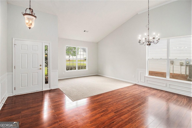 foyer with vaulted ceiling, a chandelier, and wood finished floors