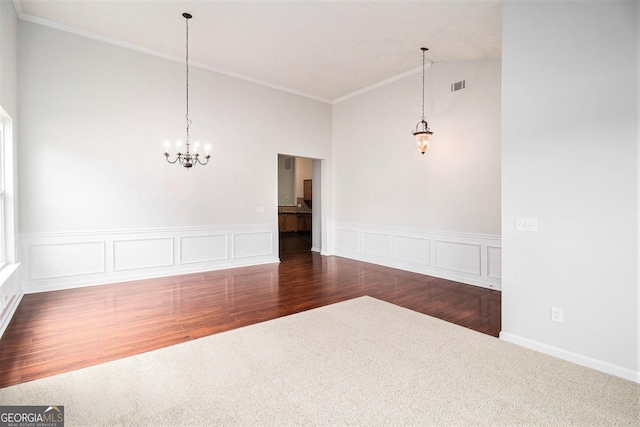 unfurnished dining area with a chandelier, high vaulted ceiling, carpet flooring, ornamental molding, and a wainscoted wall
