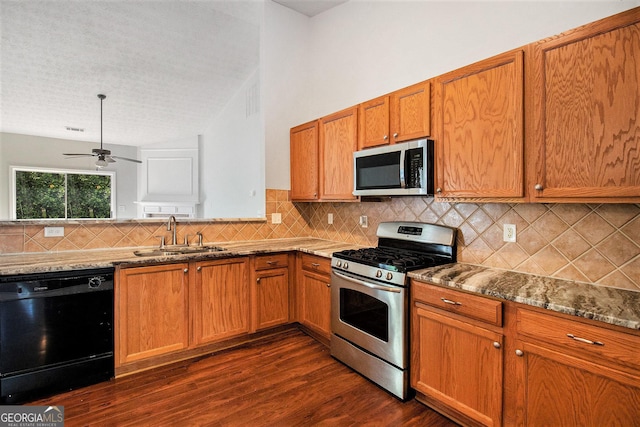 712 Brambling Way, Stockbridge, GA 30281 - kitchen featuring stainless steel appliances, dark wood-style floors, brown cabinetry, stone countertops, and tasteful backsplash