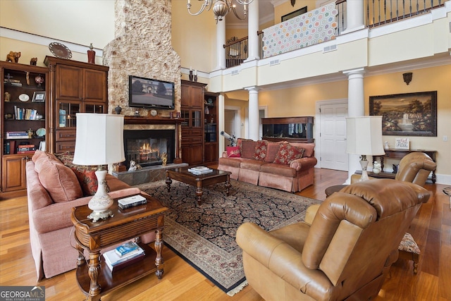 19410 Ga Highway 169, Claxton, GA 30417 - living room featuring decorative columns, a high ceiling, a fireplace, crown molding, and a chandelier