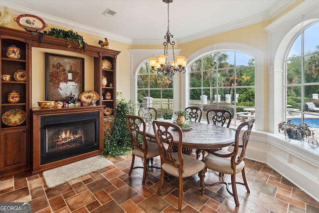 19410 Ga Highway 169, Claxton, GA 30417 - dining area with a glass covered fireplace, a chandelier, crown molding, and stone finish floors
