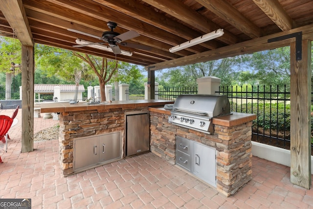 19410 Ga Highway 169, Claxton, GA 30417 - view of patio / terrace with area for grilling, an outdoor kitchen, fence, a ceiling fan, and a sink