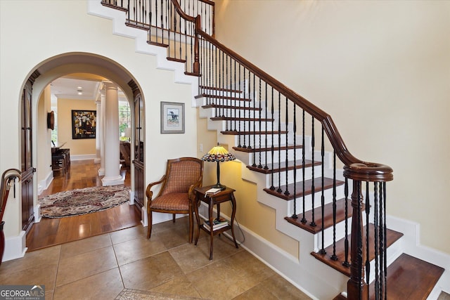 19410 Ga Highway 169, Claxton, GA 30417 - staircase with decorative columns, arched walkways, baseboards, crown molding, and tile patterned flooring