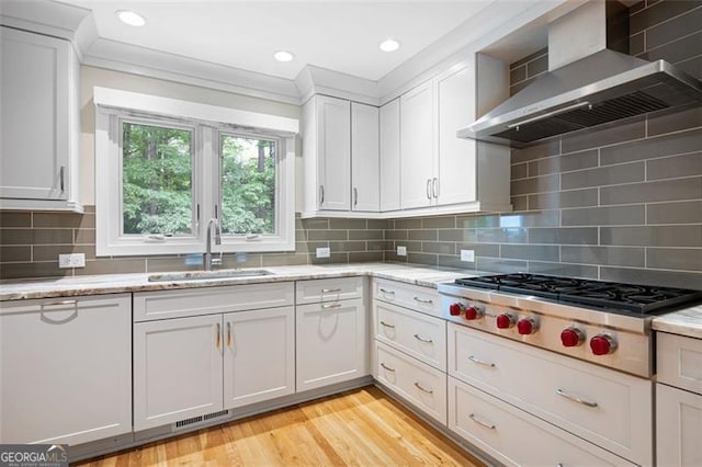 465 Willowbrook Dr, Smyrna, GA 30082 - kitchen featuring wall chimney exhaust hood, a sink, stainless steel gas cooktop, white cabinetry, and light wood-type flooring