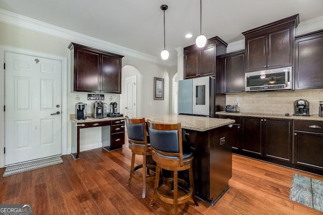110 Bluegrass Cir, Guyton, GA 31312 - kitchen with stainless steel appliances, arched walkways, dark wood-style floors, backsplash, and crown molding