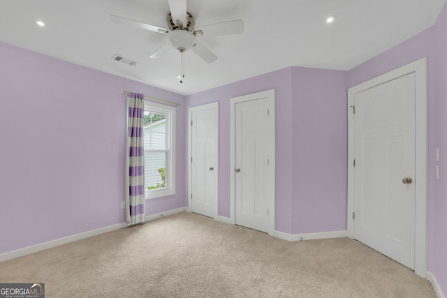 unfurnished bedroom with light carpet, baseboards, multiple closets, a ceiling fan, and recessed lighting
