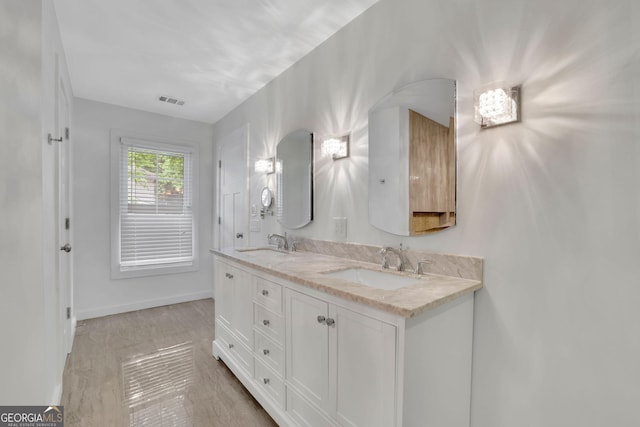 full bath with baseboards and double vanity