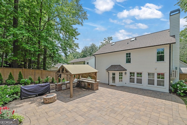 view of patio with a fire pit, a gazebo, and fence