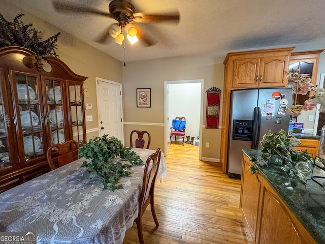 dining space featuring a ceiling fan, light wood finished floors, a textured ceiling, and baseboards