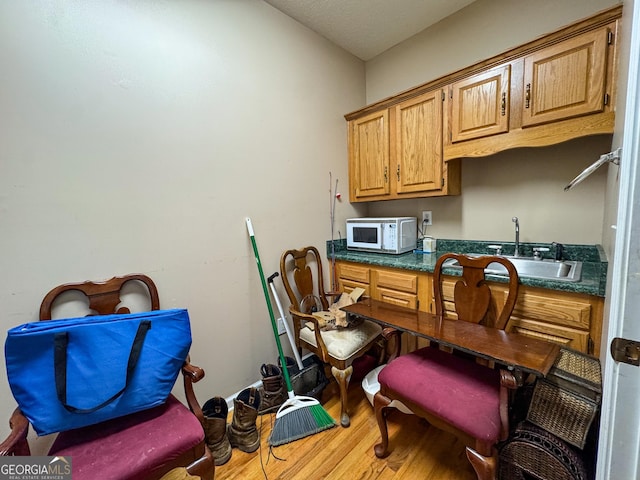 home office with a sink and wood finished floors