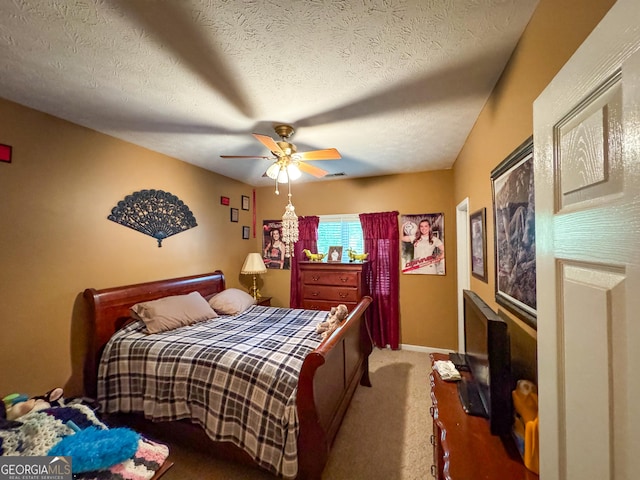 carpeted bedroom with a ceiling fan and a textured ceiling