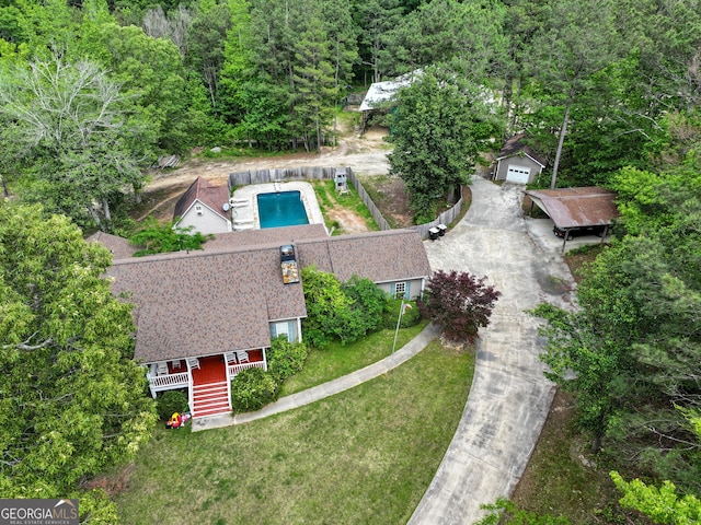 aerial view of property and surrounding area with a heavily wooded area and a pool