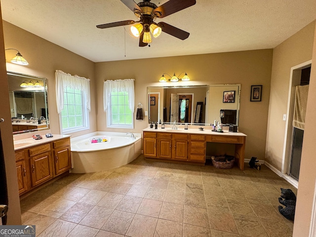 bathroom featuring a bath, a ceiling fan, two vanities, a textured ceiling, and tile patterned flooring