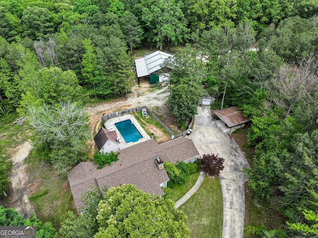 view of property location featuring a pool and a forest