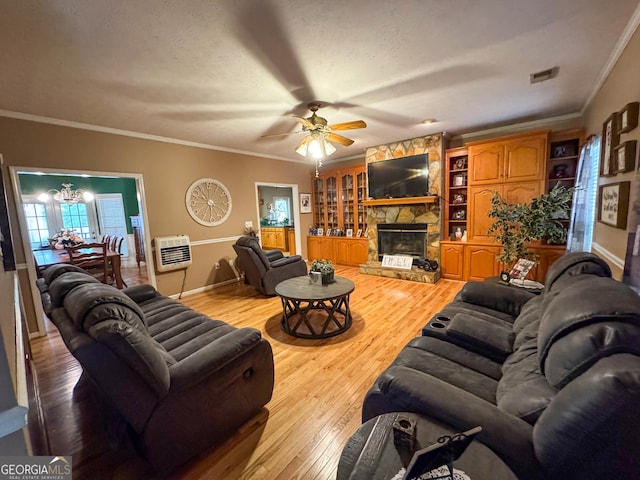 living room with a fireplace, a ceiling fan, light wood finished floors, heating unit, and ornamental molding