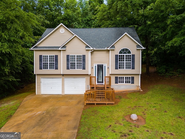 130 Opal Ln, Carrollton, GA 30116 - raised ranch featuring concrete driveway, a front lawn, an attached garage, a shingled roof, and view of scattered trees