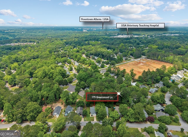 aerial view of property and surrounding area featuring a heavily wooded area and property boundaries highlighted