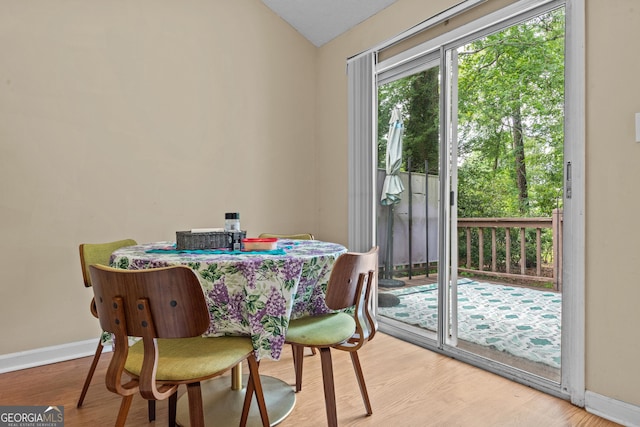 dining room featuring baseboards, wood finished floors, and lofted ceiling