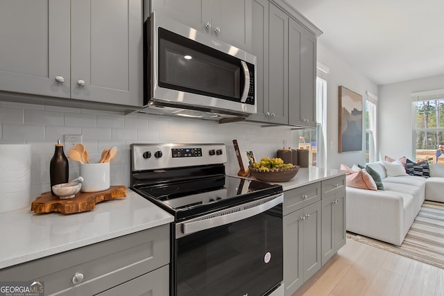 3142 Washburn St, Atlanta, GA 30354 - kitchen with appliances with stainless steel finishes, gray cabinets, backsplash, and light countertops