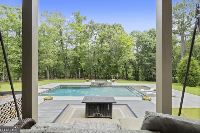 106 Chase Ln, Forsyth, GA 31029 - view of pool featuring a wooden deck, view of wooded area, and a pool with connected hot tub