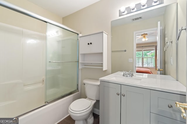 full bathroom featuring toilet, vanity, a ceiling fan, and combined bath / shower with glass door