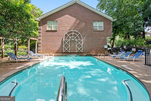 community pool featuring fence and a patio