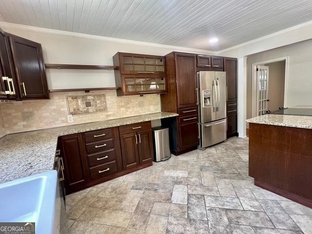 617 Smith St S, Bremen, GA 30110 - kitchen featuring stainless steel refrigerator with ice dispenser, open shelves, tasteful backsplash, ornamental molding, and light stone counters