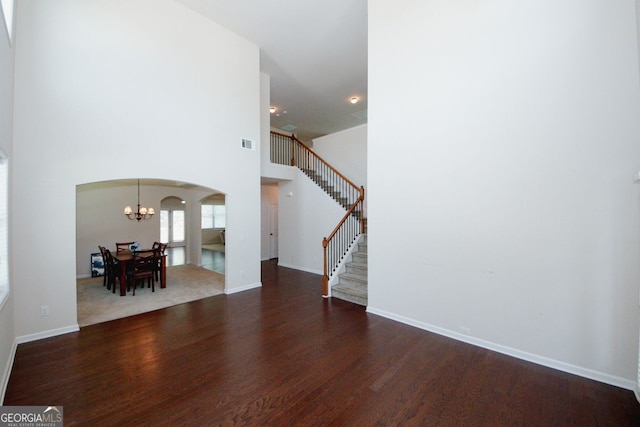 2405 Brisbane Dr, Conyers, GA 30013 - foyer entrance with arched walkways, stairway, a chandelier, wood finished floors, and baseboards
