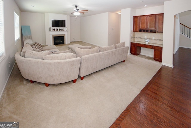 2405 Brisbane Dr, Conyers, GA 30013 - living area featuring ceiling fan, wood finished floors, baseboards, a fireplace, and stairs
