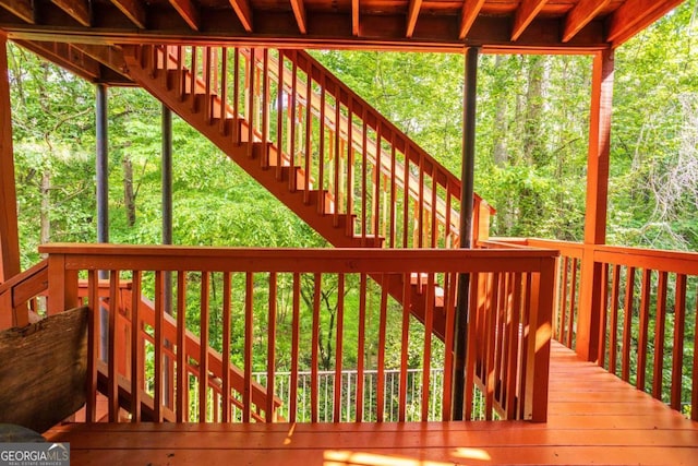 wooden deck featuring stairs and a view of trees