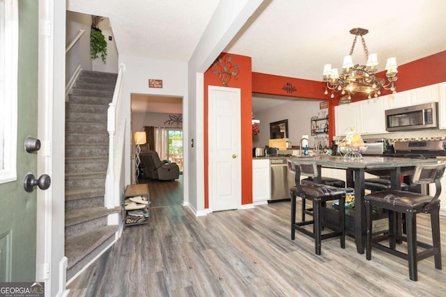 9155 Nesbit Ferry Rd Unit 96, Alpharetta, GA 30022 - dining room with stairs, a chandelier, and light wood-style floors