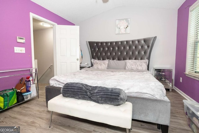 bedroom featuring wood finished floors and vaulted ceiling