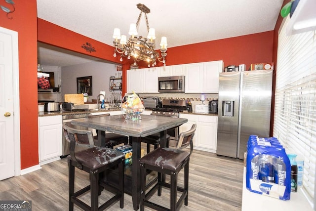 9155 Nesbit Ferry Rd Unit 96, Alpharetta, GA 30022 - kitchen with appliances with stainless steel finishes, a chandelier, light wood-style floors, and plenty of natural light