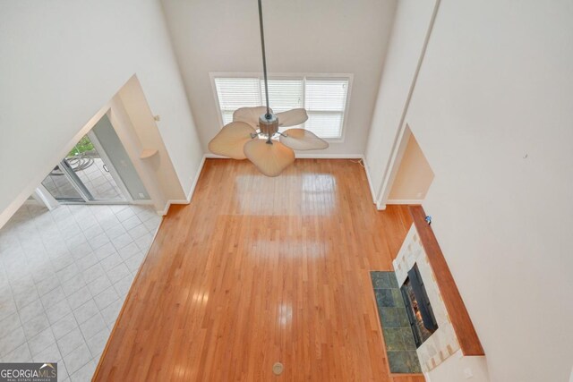 175 Palmera Ln, Brunswick, GA 31525 - unfurnished living room featuring healthy amount of natural light, a fireplace, baseboards, wood finished floors, and a high ceiling