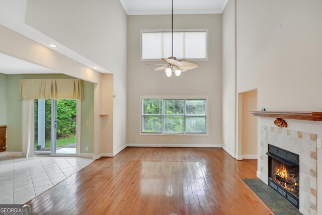 175 Palmera Ln, Brunswick, GA 31525 - unfurnished living room with a fireplace, a towering ceiling, plenty of natural light, ceiling fan, and hardwood / wood-style floors