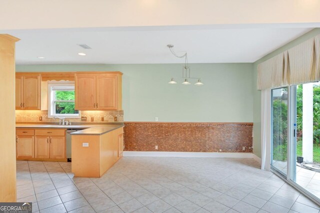 175 Palmera Ln, Brunswick, GA 31525 - kitchen with light brown cabinetry, dishwasher, a peninsula, light tile patterned floors, and baseboards