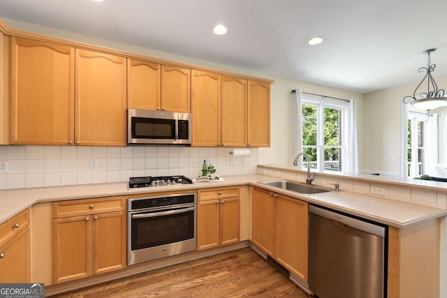 210 Wentworth Ter, Alpharetta, GA 30022 - kitchen with appliances with stainless steel finishes, a peninsula, wood finished floors, light countertops, and tasteful backsplash
