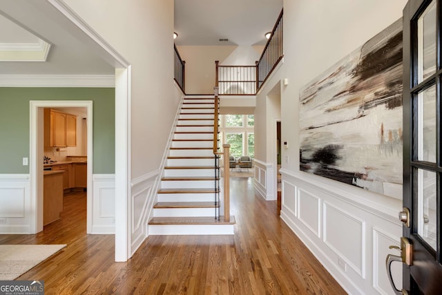 210 Wentworth Ter, Alpharetta, GA 30022 - stairs with a decorative wall, wainscoting, wood finished floors, and ornamental molding