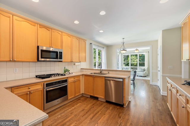 210 Wentworth Ter, Alpharetta, GA 30022 - kitchen featuring appliances with stainless steel finishes, a sink, a peninsula, light countertops, and dark wood-style floors