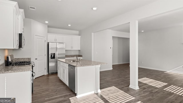kitchen featuring appliances with stainless steel finishes, a sink, dark wood-type flooring, white cabinets, and recessed lighting
