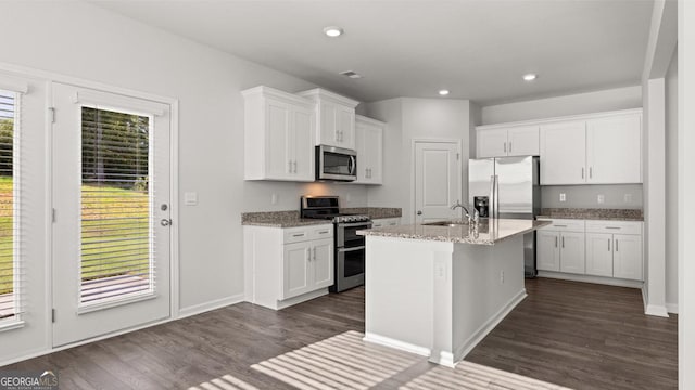 kitchen with appliances with stainless steel finishes, dark wood-style flooring, white cabinets, light stone countertops, and recessed lighting