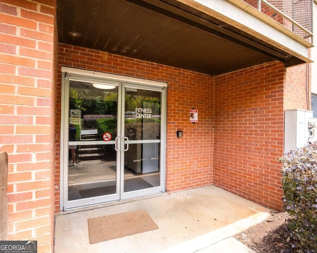 entrance to property featuring brick siding and french doors
